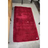 A vintage fireside rug, in deep maroon pile, approx. 135 x 70cm