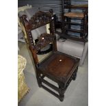 A period oak solid seat hall chair having carved back