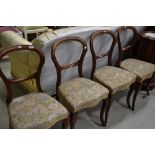 A set of four Victorian mahogany balloon back chairs having later upholstery