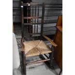 A period Lancashire spindle back rocking chair having rush seat