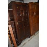 An early 20th Century Jacobean inspired wardrobe or hall robe in dark oak