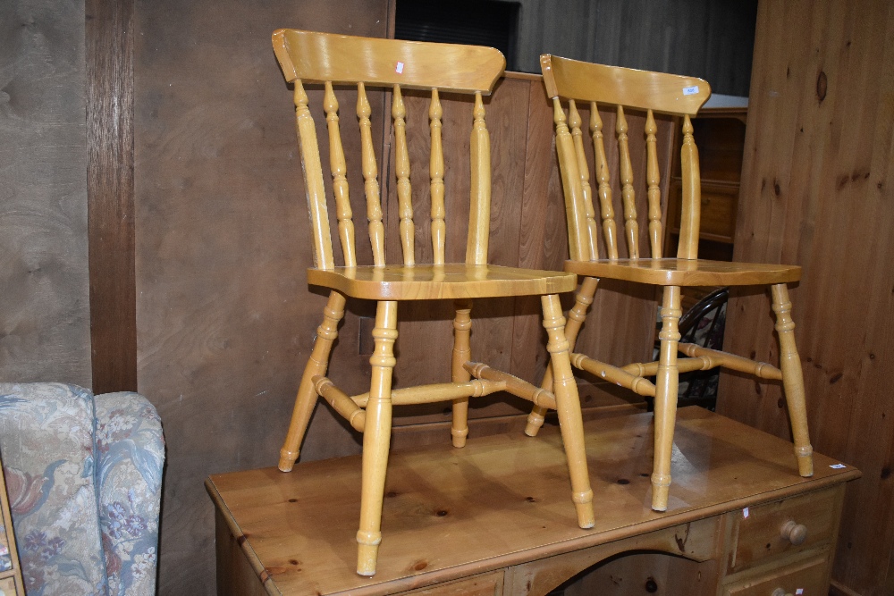 A pair of traditional rubberwood kitchen chairs