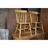 A pair of traditional rubberwood kitchen chairs