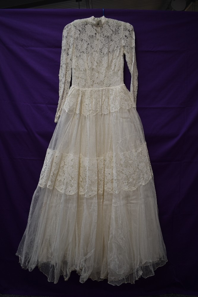 A vintage 1950s tulle and lace wedding dress having rhinestone details throughout,high neckline