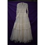 A vintage 1950s tulle and lace wedding dress having rhinestone details throughout,high neckline