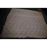 An early 20th century floral cotton bed throw,cotton wool filled, some age related wear.