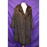 A vintage mid length brown fur coat.