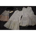 A collection of vintage petticoats one having beautiful flocked floral pattern and a long line black