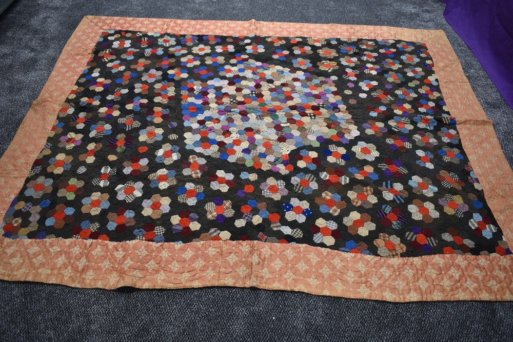 A stunning Victorian patchwork quilt having hexagons to centre surrounded by a border. beautifully