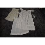 Three antique items of baby clothing including one long gown with cut work and embroidered hem,