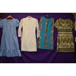 Four vintage dresses having bright patterns in a variety of fabrics and styles,small and medium