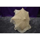 An early 20th century cream slub silk parasol with an abundance of tulle lace surrounding the