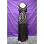 A black full length lace 1930s evening gown having half belt to back and full panelled skirt.