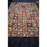 A large retro quilt made up of sections of autumnal shades of tie dyed cotton.