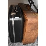 Two retro suitcases, one being a sturdy black antler case.