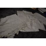 A collection of white work table linen including damask table cloths and more.