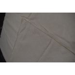 An antique white marsella bed throw having floral pattern with urn motifs and more.