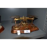 A set of antique brass post office scales reading Postal Rates for Letters with assortment of