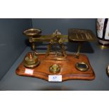 A set of antique brass post office scales reading Postal Rates for Letters with assortment of