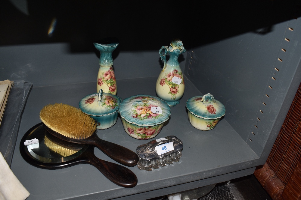 A ceramic dressing table set and similar ebony brush and mirror set