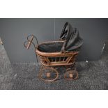 A modern reproduction Victorian style Dolls Pram having wicker frame and metal wheels