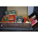A vintage travel case containing a collection of vintage games and jigsaws including Monopoly,