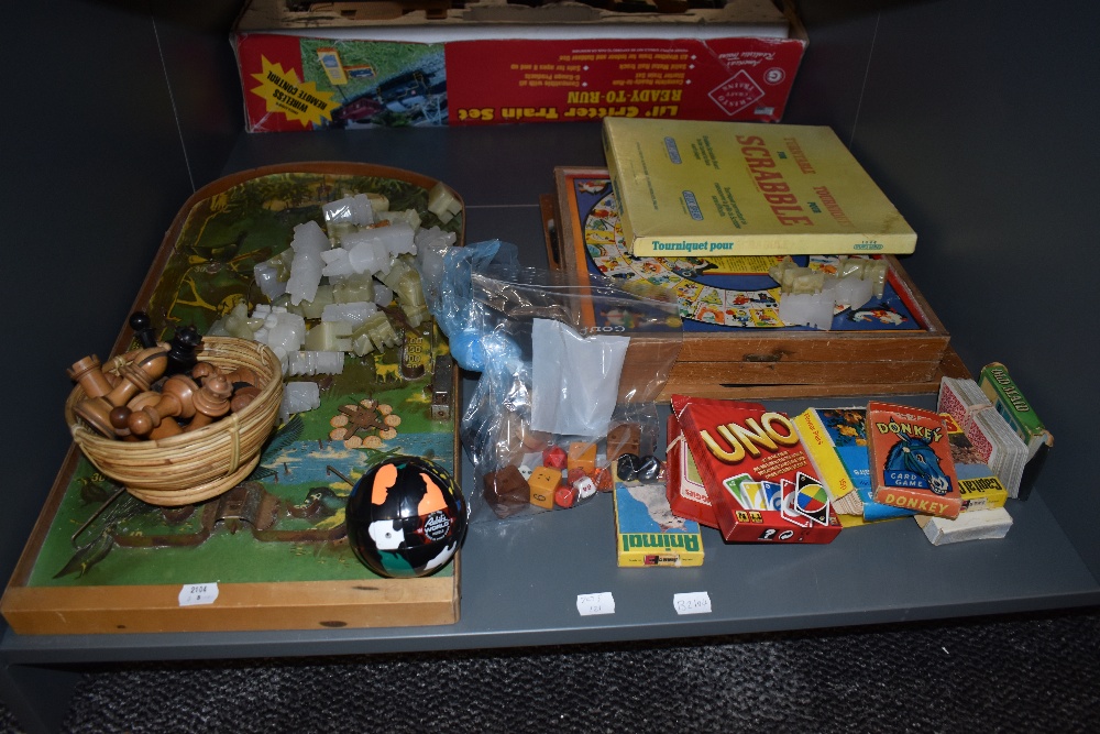 A shelf of vintage toys and games including French Jeu De L'oie folding board game, Scrabble