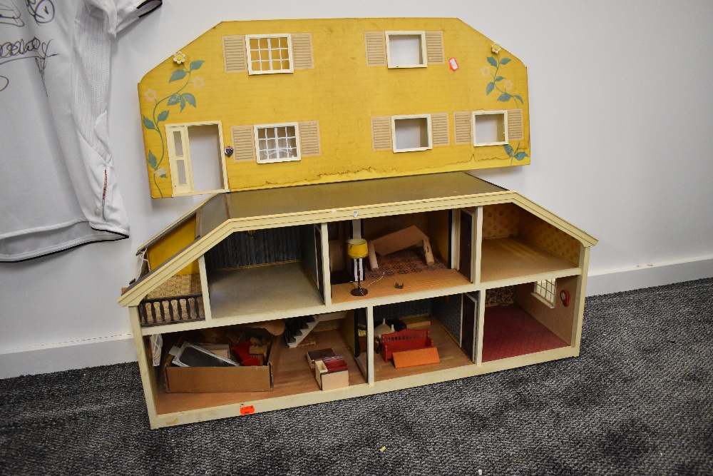 A 1970's style wooden two storey Dolls House having a small selection of wooden and plastic