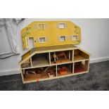 A 1970's style wooden two storey Dolls House having a small selection of wooden and plastic