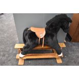 A modern Mamas & Papas plush Rocking Horse with saddle on tradition wooden swing action base