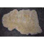 A pale colour sheep skin rug or throw