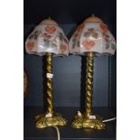 A pair of early 20th century library or desk top lights having brass twist stems with pressed pink