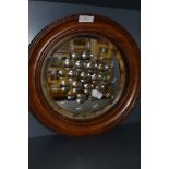 An oak framed circular Edwardian mirror having multiple bulls eye and star designs