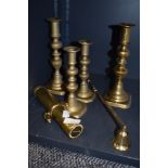 Four brass candle stick holders,a snuffer and a Brass maritime torch possibly a divers torch 'The