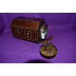 A vintage tea tin containing a collection of coins,various eras and currencies.