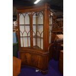 A pair of reproduction corner display cabinets, of concave form by Bevan Funnell