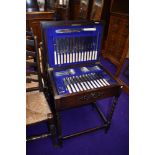 An early 20th Century oak barley twist frame canteen containing almost full set of stainless