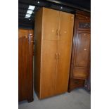 An early to mid 20th Century golden oak and sapele double cupboard, in the Gomme/G Plan style,
