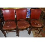 A set of six early 20th Century oak frame dining chairs having red leather seats and backs