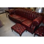A reproduction burgundy leather four seater Chesterfield settee, width approx. 250cm and two similar