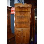 A vintage pine corner shelf with cupboard under