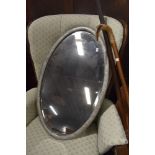 A reproduction pewter effect oval wall mirror