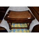 An oak framed cane seated shaped stool