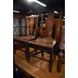 A pair of Georgian rustic mahogany solid seat chairs having splat vase backs