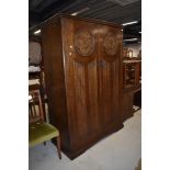 A mid 20th Century oak wardrobe and dressing table having shield and linen fold decoration, robe