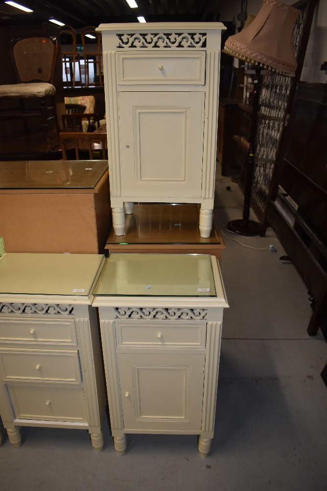 A pair of cream bedside cabinets