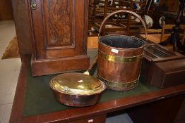 A traditional copper and brass warming pan and coal bucket