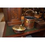 A traditional copper and brass warming pan and coal bucket