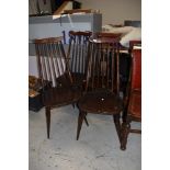 A set of four dark stained Ercol or similar high stick back kitchen/dining chairs