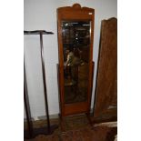 An early 20th Century golden oak cheval mirror in the Arts and Crafts style, labelled to reverse,